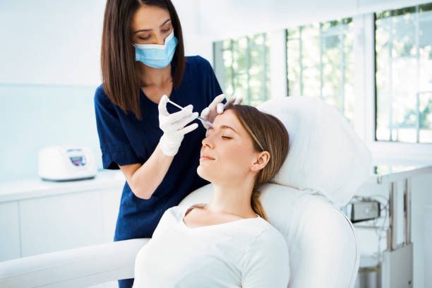 Practitioner administering an anti-wrinkle injection to the forehead